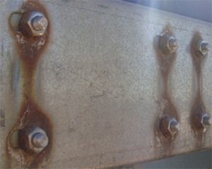 Bimetallic corrosion of mild steel bolts coupled with stainless steel plate.